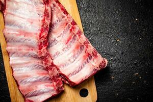 Raw ribs on a cutting board. photo