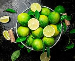 Fragrant lime with leaves in a colander. photo
