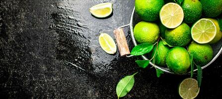 Fragrant lime with leaves in a colander. photo