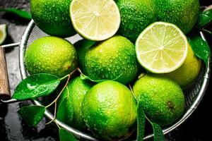 Fragrant lime with leaves in a colander. photo