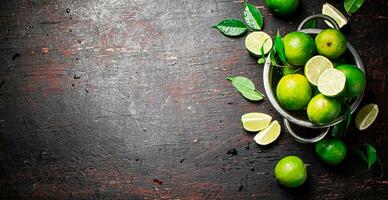 Fresh lime with leaves in a colander. photo