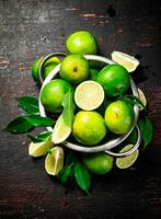 Fresh lime with leaves in a colander. photo