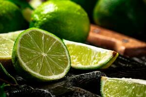 Sliced lime with leaves on a cutting board with a knife. photo