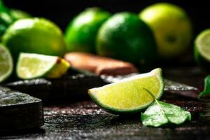 Sliced lime with leaves on a cutting board with a knife. photo