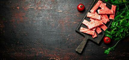 Crab meat on a cutting board with parsley and tomatoes. photo