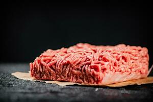 Raw minced meat on paper on the table. photo