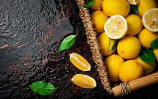 Fresh lemons with foliage in a basket. photo