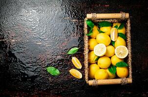 Fresh lemons with foliage in a basket. photo