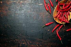 Wooden plate with hot chili peppers. photo