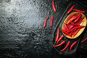 Pods of hot chili peppers on a cutting board. photo