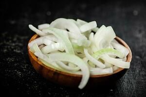 Chopped onions in a wooden plate. photo