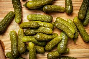 Pickled cucumbers on a wooden background. photo