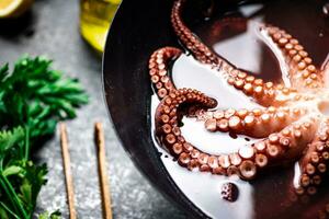 Octopus is boiled in a pot of water. photo