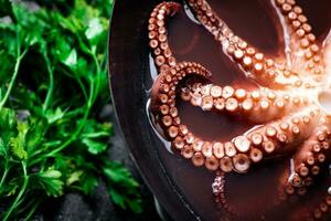 Octopus is boiled in a pot of water. photo