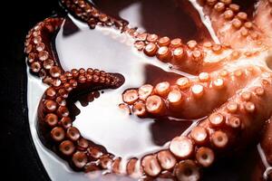 The tentacles of the octopus are boiled in water. photo