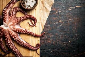 Octopus on a wooden cutting board. photo