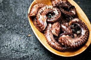 Pieces of fresh octopus. On a black background. photo