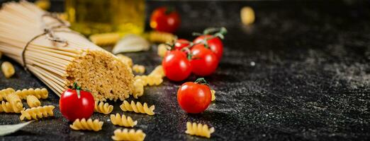 A bunch of spaghetti dry with cherry tomatoes. photo