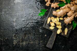 Whole and chopped ginger on a cutting board. photo