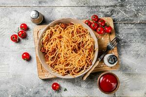 espaguetis boloñesa con Cereza Tomates en el mesa. foto