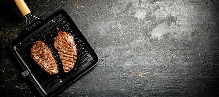 Delicious grilled steak in a frying pan. photo