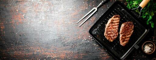 Aromatic grilled steak in a frying pan. photo