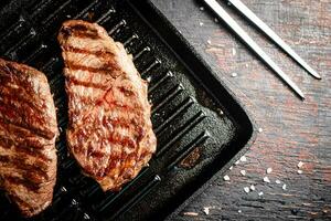 Aromatic grilled steak in a frying pan. photo