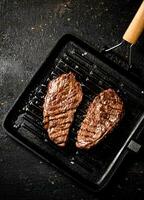 Delicious grilled steak in a frying pan. photo
