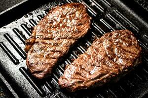 Delicious grilled steak in a frying pan. photo