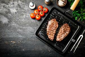 Grilled steak in a frying pan with tomatoes and spices. photo