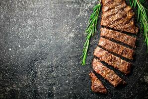 Grilled steak with a sprig of rosemary. photo