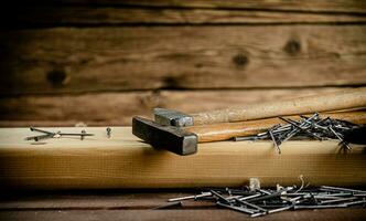 Hammer with a bunch of nails on the table. photo