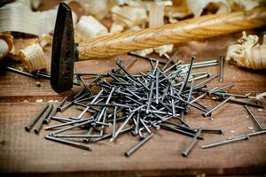 Hammer with a bunch of nails on the table. photo