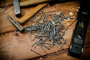 Hammer with a bunch of nails on the table. photo