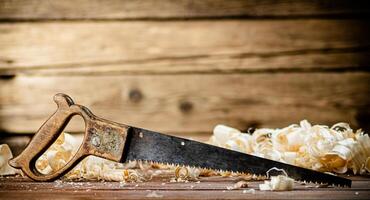 Hand saw with wooden shavings. photo