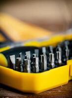 Working tools. Screwdriver bits. On a wooden background. photo