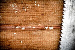 Hand saw blade on a wooden background. photo