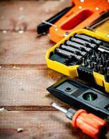 Working tools. Screwdriver bits. On a wooden background. photo