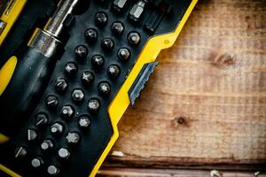 Working tools. Screwdriver bits. On a wooden background. photo