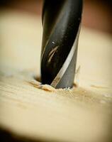 Piece of wood is drilled with shavings. photo