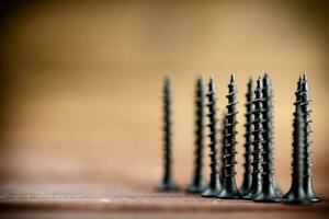 Self-tapping screw on wood on the table. photo