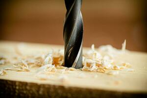 Piece of wood is drilled with shavings. photo