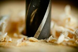 Piece of wood is drilled with shavings. photo