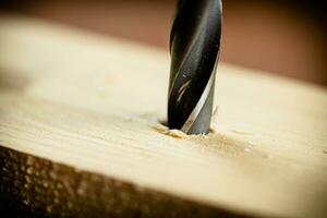 Piece of wood is drilled with shavings. photo