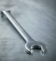 Metal wrench on the table. photo