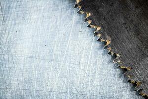 The blade of a hand saw on a gray background. photo