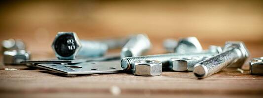 Metal plates for fastening. On a wooden background. photo