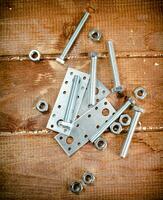 Metal plates for fastening. On a wooden background. photo