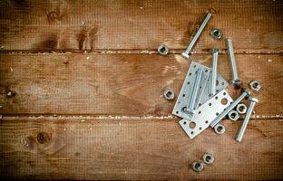 Metal plates for fastening. On a wooden background. photo