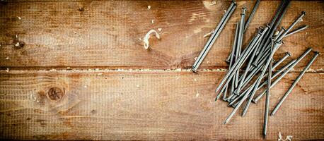 Nails on the table. On a wooden background. photo